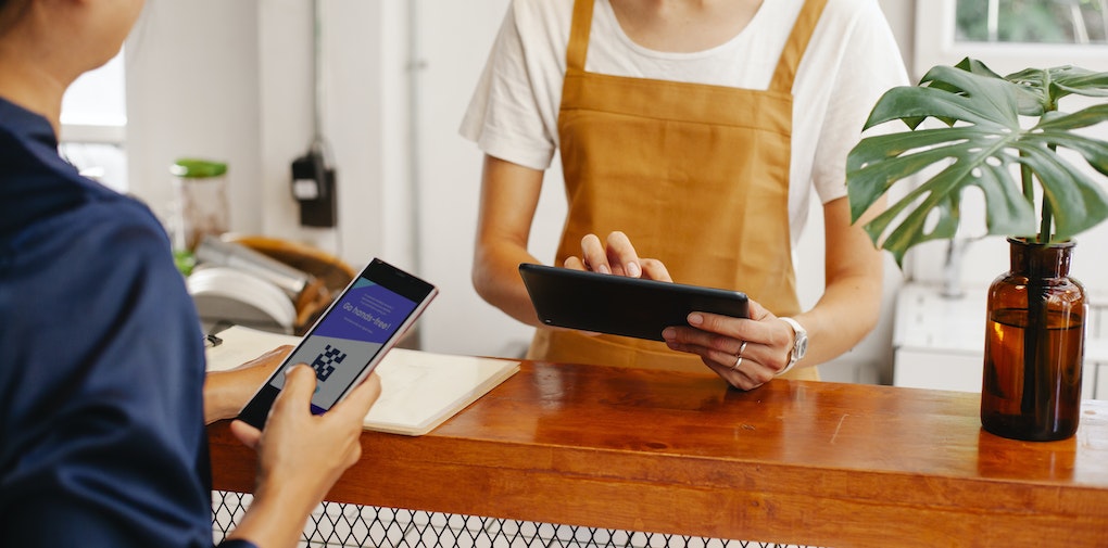 Customer using loyalty app on his mobile phone at the counter in a shop